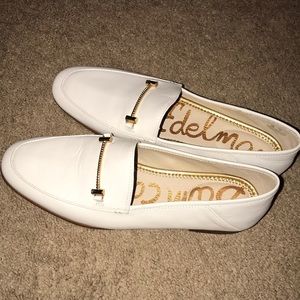 a WHITE LOAFER W GOLD ACCENT